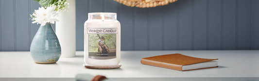 A large ‘Happy Birthday’ Yankee Candle with a photograph of a son and father on the label.