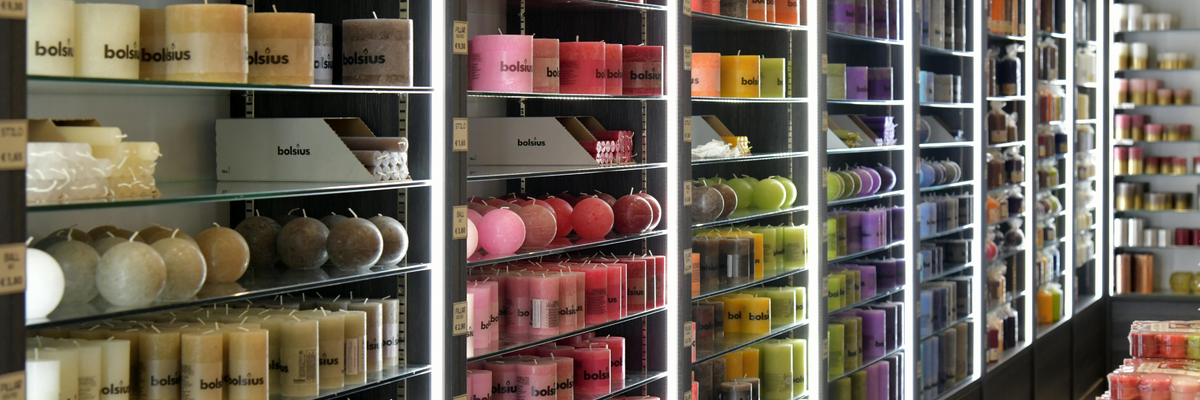 Different types of colourful candles stocked up on a shop floor.