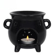 Black ceramic oil burner with a lit tealight candle on a white background