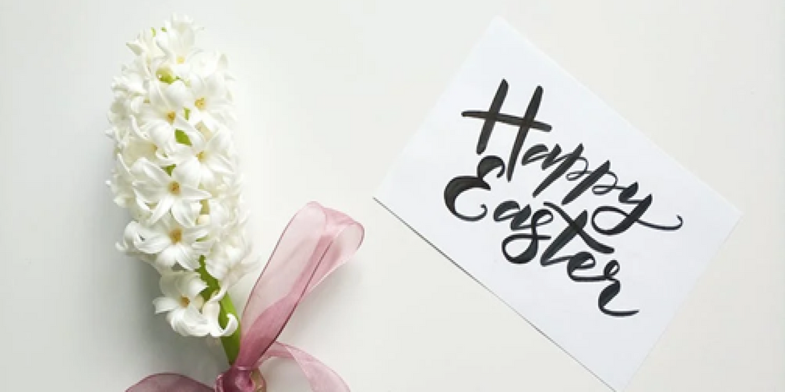 Flowers wrapped in a bow next to a note that says “Happy Easter”. Sourced from Pexels.