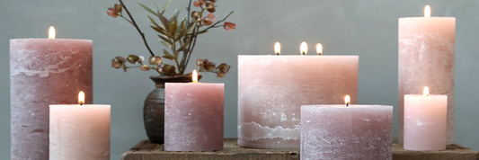 A display of rose pink pillar candles in different widths and heights. Sourced from Gracie Jaynes