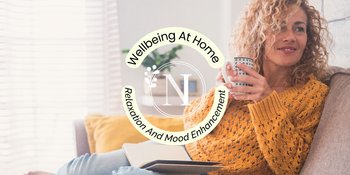 a woman relaxing at home with a cup of tea and a candle burning to promote a calming home environment