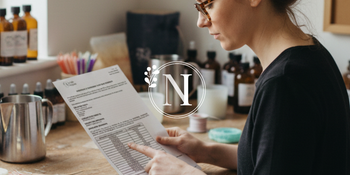 a woman reading an IFRA Certificate for a fragrance oil