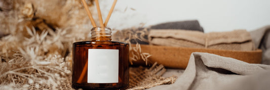 Amber glass room diffuser with fragrance sticks, among a rustic backdrop. Sourced from Pexels.