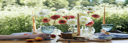 A springtime table setting with flowers and tapered outdoor candles. Source: Pexels