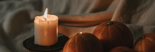 Ambient setting with rustic handmade candles and mini pumpkins.
