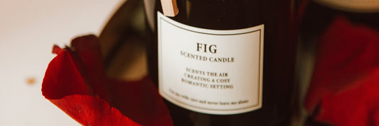 A fig-scented candle with a CLP label on a tray with scattered rose petals. Sourced from Pexels.
