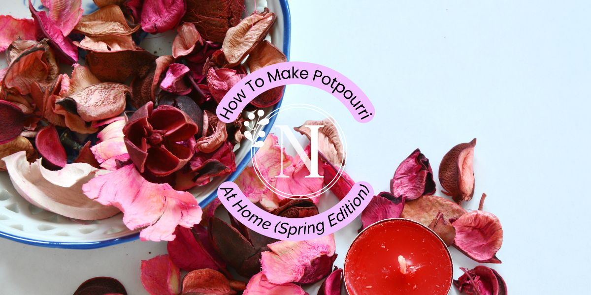 Colourful, dried flowers such as sprigs of lavender and rose petals on a wooden table