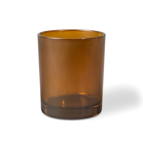 Amber glass candle tumbler on a white background