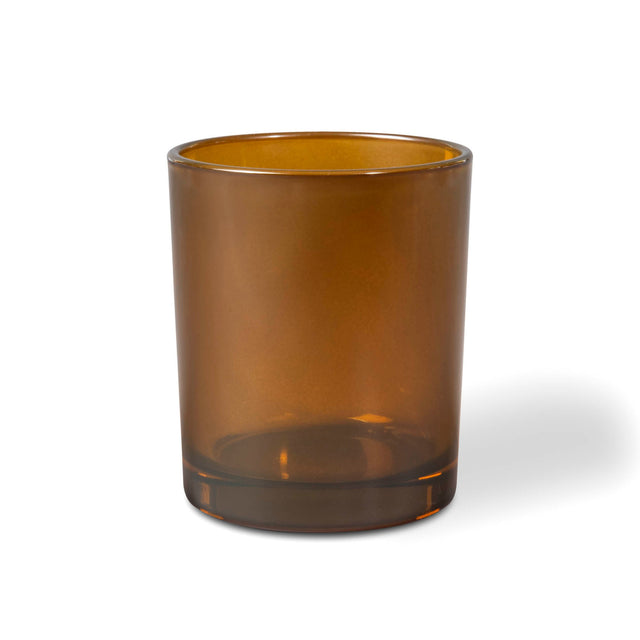 Amber glass candle tumbler on a white background