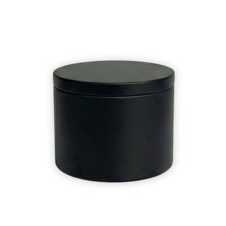 Black candle tin with lid on a white background