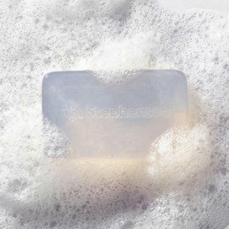Bar of soap with 'Stephenson's' branding on a foamy  background