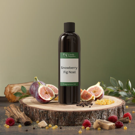 Fragrance oil bottle labeled 'Snowberry Fig Noel' on a wooden platform with fruits and leaves.