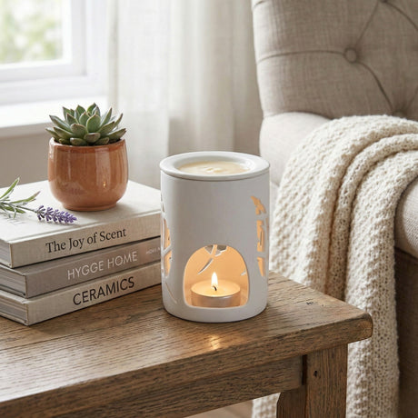 Wax warmer on a wooden table with books and a plant in the background